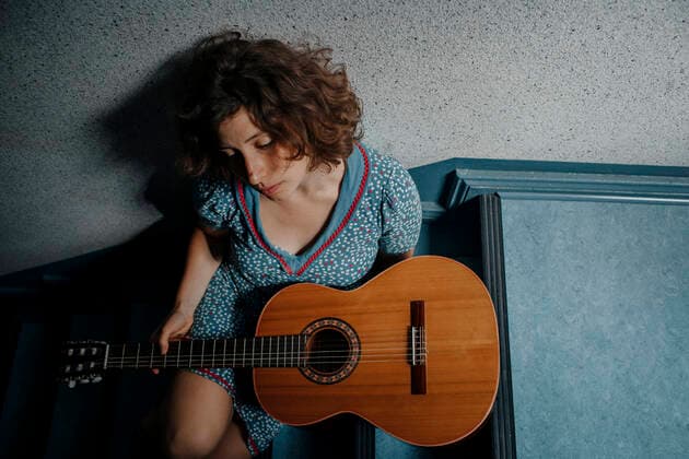 Sad young woman sitting on stairs with guitar model released Symbolfoto  OGF00204