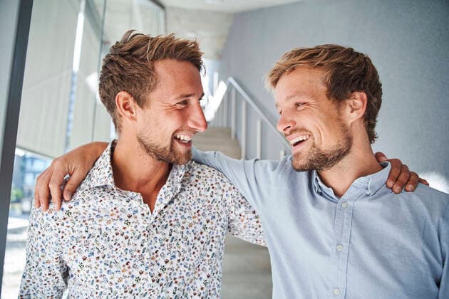 Portrait of two happy young businessmen embracing model released Symbolfoto  PNEF02360