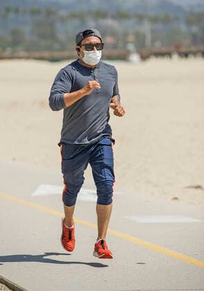 April 2, 2020, Santa Barbara, California, USA: A jogger wearing a face mask runs along an empty West Beach. The White House is expected to urge Americans to begin wearing cloth face masks in public to help prevent the spread of the coronavirus. Santa Barbara USA - ZUMAh13_ 20200402_zaf_h13_002 Copyright: xPJxHellerx