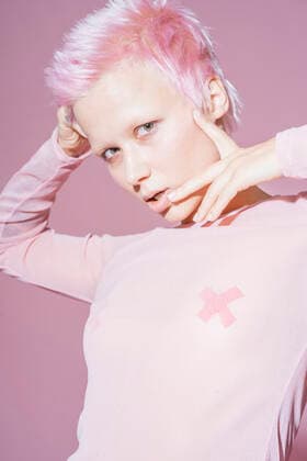 IMAGO Creative, Lifestyle, Barbiecore Portrait of young woman with short pink hair wearing pink top in front of pink background model released Symbolfoto  VPIF02107