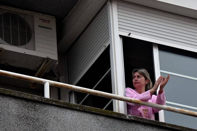 April 2, 2020, El Vendrell, Spain: A woman applauds from the terrace of her house to show gratitude to the Covid-19 fighters..In Spain, every night at 08:00 pm and all the cities of the country, citizens who are confined at home during the state of alarm decreed by the Government of Spain since March 16, go out to their terraces and applaud to show gratitude to all the people such as health workers, police, fire fighters, supermarket staff, truckers, and cleaning staff for their great work in fighting the Covid-19 crisis. El Vendrell Spain - ZUMAs197 20200402_zaa_s197_078 Copyright: xRamonxCostax
