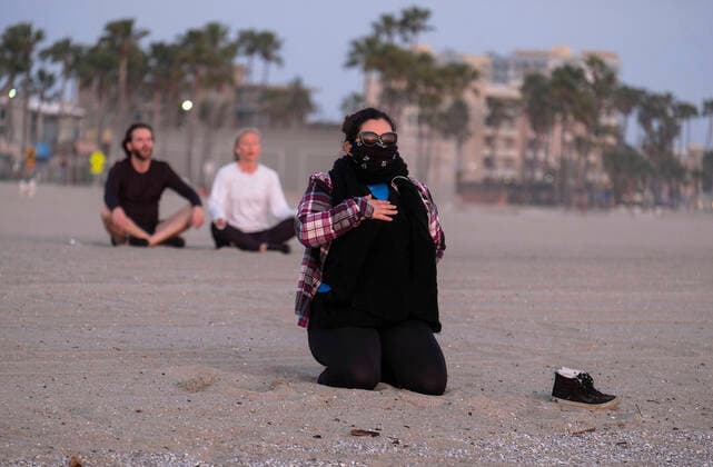 April 2, 2020, Los Angeles, California, U.S: A woman prays while watching the sunset in Venice Beach on April 2, 2020 in Los Angeles. Los Angeles County coronavirus cases surged past the 4,000 mark today, while health officials reported another 13 deaths and warned residents that wearing a mask. Los Angeles U.S. - ZUMAc68_ 20200402_zaf_c68_014 Copyright: xRingoxChiux