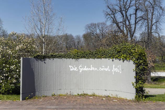 DEU, Deutschland, Baden-Württemberg, Stuttgart, 03.04.2020: Stadtbahn Haltestelle Mineralbäder in Stuttgart. Ein Sprayer schreibt auf eine Betonwand: Die Gedanken sind frei! . Die Gedanken sind frei ist ein deutsches Volkslied über die Gedankenfreiheit.