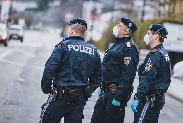 03.04.2020, Zell am See, AUT, Coronavirus in Oesterreich, im Bild Polizisten mit Schutzmasken beim Kontrollpunkt in die unter Quarantaene gestellten Bezirkshauptstadt waehrend der Coronavirus Pandemie Police officers wearing protective masks at the checkpoint into the quarantined City during the World Wide Coronavirus Pandemic in Zell am See, Austria on 2020 04 03.