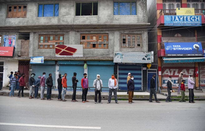 April 3, 2020, Srinagar, Jammu & Kashmir, India: Non local workers maintain the social distance as a preventive measure while in queue receiving aid from a local non government organisation, during the lockdown..Indian Prime Minister, Narendra Mondi announced 21 day lockdown on 22 March across the country restricting the movement of people from stepping out of their home to curb the spread of the corona virus. More than 2500 tested positive for corona virus in India with 71 deaths. Srinagar India - ZUMAs197 20200403_zaa_s197_079 Copyright: xIdreesxAbbasx