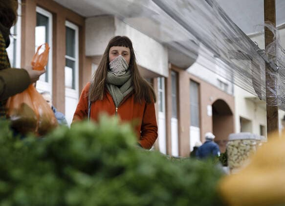 Eine Frauen mit Mundschutz, kauft auf einem Wochenmarkt in Berlin ein. 03.04.2020. Berlin Deutschland
