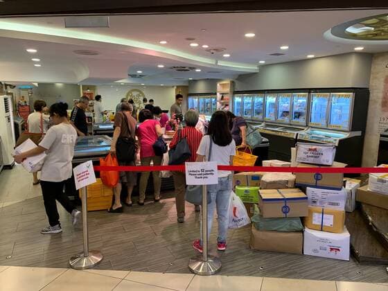 A sign indicates a restriction on the number of people allowed in a store at the seafood market place Chinatown after the Singapore government announced tighter restrictions to fight the spread of the COVID-19 virus in Singapore on April 4, 2020.  (125033601)