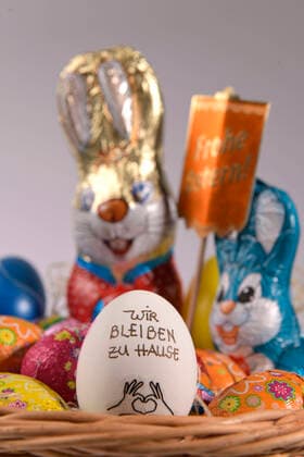 04.04.2020, Symbolbild: An Ostern 2020 bleiben wir zu Hause. Slogan Wir bleiben zu Hause auf einem Hühnerei im Osternest. Aktion wegen der Corona-Krisen-Ausgangsbeschränkung in Deutschland. 04.04.2020, Ostern zuhause bleiben 04.04.2020, Ostern zuhause bleiben