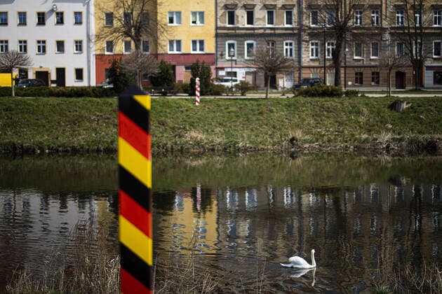 Ein Schwan schwimmt auf der Neisse mit Blick auf die polnische Nachbarstadt Zgorzelec, in Goerlitz, 04.04.2020. In der Nacht vom 14.03. zum 15.03. wurden die Grenzen zwischen Deutschland und Polen sowie Tschechien geschlossen, um die Ausbreitung des Coronaviruses einzudaemmen. Goerlitz Deutschland