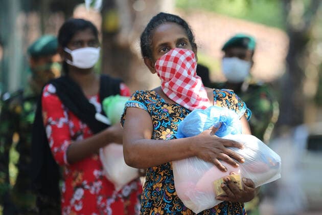 April 4, 2020, Colombo, Sri Lanka: A Sri Lanken woman carries packages of dry rations of food and commodities distributed by Sri Lankan police Special Task Force during the island-wide curfew..The Sri Lankan government has implemented an island-wide curfew until further notice in order to slow down the spread of the SARS-CoV-2 coronavirus that causes the COVID-19 disease. To date Sri Lanka has confirmed at least 162 novel coronavirus infections with five deaths and 25 recovered. Colombo Sri Lanka - ZUMAs197 20200404_zaa_s197_069 Copyright: xHarshanaxJohanasx