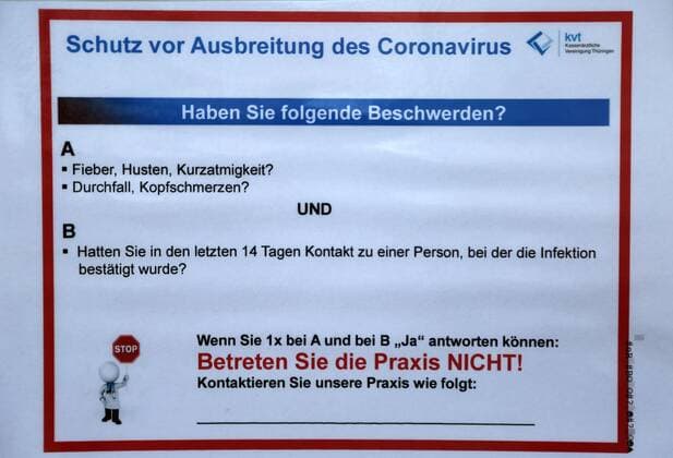Corona 04.04.2020 , Erfurt, die Innenstadt ist aufgrund der Corona-Krise wie ausgestorben, die Menschen sollen so gut es geht, zu Hause bleiben im Bild: Schild an einer Arztpraxis mit der Information zu Corona, wer Symptome hat, soll die Praxis nicht betreten