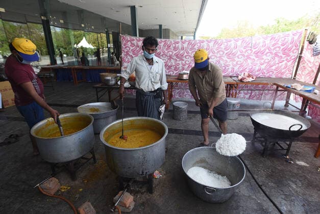 NEW DELHI, INDIA - APRILl 4: Meals sanctioned by the Dehi government being prepared for migrant workers and the homeless at a temporary shelter, on day eleven of the nationwide lockdown to check the spread of coronavirus, at Yamuna Sports Complex, on April 4, 2020 in New Delhi, India. (Photo by Sonu Mehta Hindustan Times ) Government And NGOs Provide Food To Homeless And Poor Amid Lockdown To Prevent Covid-19