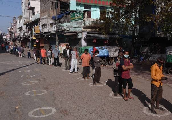 NEW DELHI, INDIA - APRILl 4: Daily wage workers and homeless people stand in a queue while maintaining social distance to collect foodon day eleven of the 21 day nationwide lockdown to curb the spread of coronavirus, at Paharganj, on April 4, 2020 in New Delhi, India. (Photo by Biplov Bhuyan Hindustan Times ) Government And NGOs Provide Food To Homeless And Poor Amid Lockdown To Prevent Covid-19