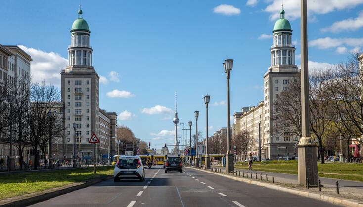 Coronavirus in Berlin Berlin, 04.04.2020, Frankfurter Tor. Wegen des Coronavirus zeigt sich die Frankfurter Allee ungewoehnlich menschenleer. Auf der Strasse ist wenig Verkehr und wenige Fussgaenger kreuzen mit grossem Abstand. Im Hintergrund Türme am Frankfurter Tor und Fernsehturm bei strahlendem Sonnenschein. Berlin Berlin Deutschland City Ost