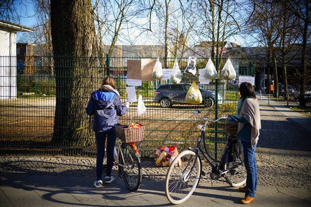 04.04.2020,Berlin,Deutschland,GER,die Stadt in Zeiten der Corona Pandemie.Zwei Frauen stehen vor einen Gabenzaun mit ihren Fahrrädern.Gesehen am Stuttgarter Platz.