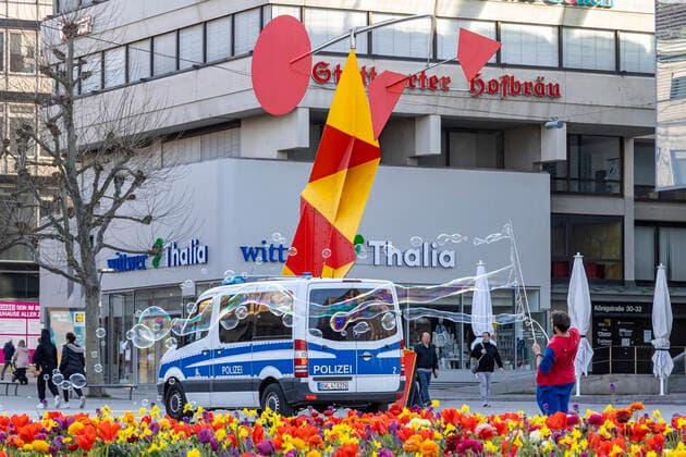 DEU, Deutschland, Baden-Württemberg, Stuttgart, 04.04.2020: Kontaktsperre zeigt Wirkung: Trotz schönen Frühlingwetters halten sich die meisten Menschen an die Kontaktsperre und sind allein oder zu zweit unterwegs. Vor dem Kunstmuseum am Schlossplatz erzeugt ein Straßenkünstler Seifenblasen.