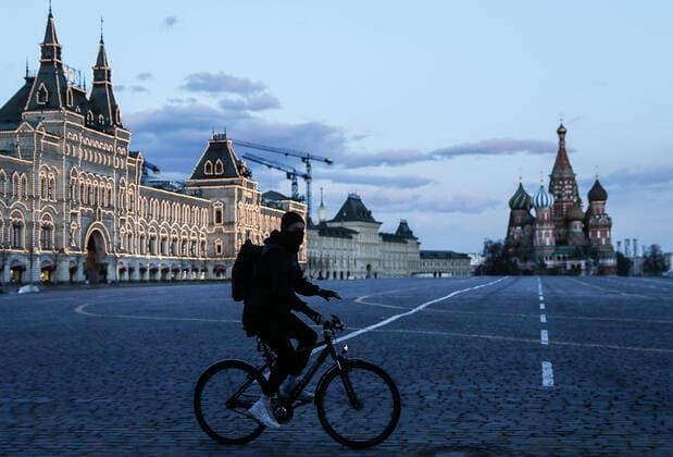 MOSCOW, RUSSIA - APRIL 4, 2020: A man rides a bicycle in a deserted Red Square. Russian President Vladimir Putin has expanded non-working period till April 30, 2020 to prevent the spread of the novel coronavirus. Sergei Savostyanov TASS  TS0D4727