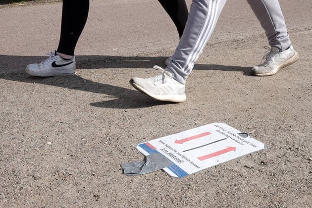 Kontaktverbot - Außenalster 04.04.2020, DEU, Deutschland, Hamburg: Menschen sind an der Alster während des Kontaktverbots wegen der Coronakrise unterwegs. Auf dem Boden liegt ein Schild mit 2 Pfeilen, darauf ist die Aufschrift **Zu ihrer Sicherheit herrscht hier Richtungsverkehr - Bitte halten sie zusätzlich immer 2 Meter Abstand**. Hamburg Hamburg Deutschland