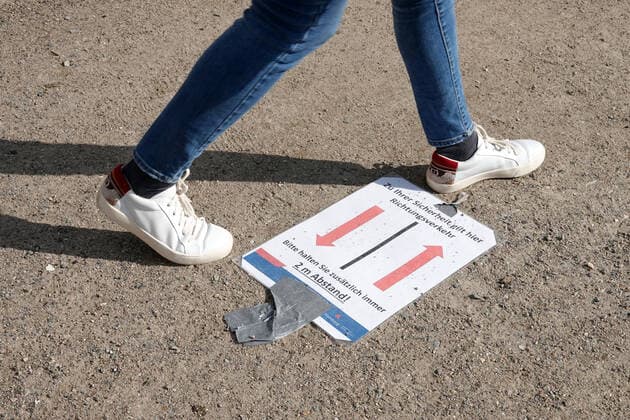 Kontaktverbot - Außenalster 04.04.2020, DEU, Deutschland, Hamburg: Menschen sind an der Alster während des Kontaktverbots wegen der Coronakrise unterwegs. Auf dem Boden liegt ein Schild mit 2 Pfeilen, darauf ist die Aufschrift **Zu ihrer Sicherheit herrscht hier Richtungsverkehr - Bitte halten sie zusätzlich immer 2 Meter Abstand**. Hamburg Hamburg Deutschland