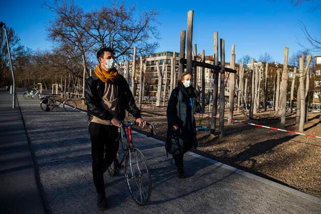 Ben und seine aeltere Mutter Elsa laufen und sprechen mit Mundschutzmaske am Gleisdreieckpark in Berlin am 4. April 2020. Um die Verbreitung des Coronavirus (SARS-CoV-2) zu verlangsamen beschlossen Bund und Laender weitere Restriktionen. Nachdem Museen, Theatern, Sportveranstaltungen usw verboten wurden sind seit einigen Tagen weitere verschaerfte Massnahmen in Kraft getreten wie z.B. Verbot von Versammlungen in der Oeffentlichkeit mit mehr als zwei Personen, Einhaltung von Mindestabstand zwischen Personen und Schliessung von Gastronomiebetrieben mit Ausnahme von Abholung und Lieferung. Coronavirus in Berlin