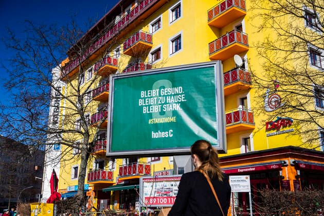 Plakat von Hohes C mit Schrift Bleibt gesund, bleibt zu Hause, bleibt stark in Berlin am 4. April 2020. Um die Verbreitung des Coronavirus (SARS-CoV-2) zu verlangsamen beschlossen Bund und Laender weitere Restriktionen. Nachdem Museen, Theatern, Sportveranstaltungen usw verboten wurden sind seit einigen Tagen weitere verschaerfte Massnahmen in Kraft getreten wie z.B. Verbot von Versammlungen in der Oeffentlichkeit mit mehr als zwei Personen, Einhaltung von Mindestabstand zwischen Personen und Schliessung von Gastronomiebetrieben mit Ausnahme von Abholung und Lieferung. Coronavirus in Berlin