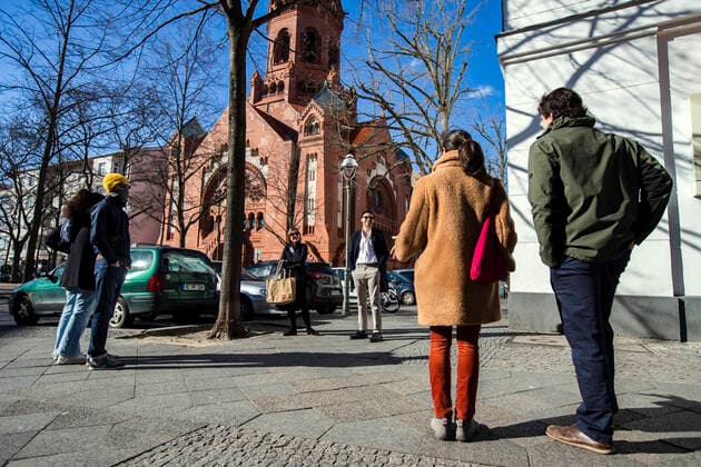 Drei Gruppen von Bekannten halten vorbildlich die Regeln des Kontaktverbots und sprechen auf Distanz in Berlin am 4. April 2020. Um die Verbreitung des Coronavirus (SARS-CoV-2) zu verlangsamen beschlossen Bund und Laender weitere Restriktionen. Nachdem Museen, Theatern, Sportveranstaltungen usw verboten wurden sind seit einigen Tagen weitere verschaerfte Massnahmen in Kraft getreten wie z.B. Verbot von Versammlungen in der Oeffentlichkeit mit mehr als zwei Personen, Einhaltung von Mindestabstand zwischen Personen und Schliessung von Gastronomiebetrieben mit Ausnahme von Abholung und Lieferung. Coronavirus in Berlin