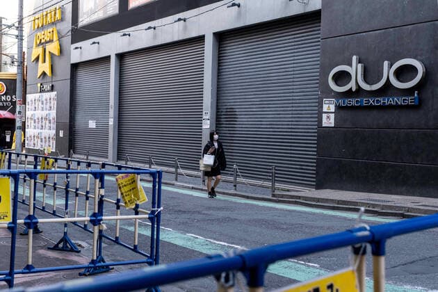 April 4, 2020, Tokyo, Japan: A woman walks past a closed store wearing a face mask as a preventive measure, during the corona virus pandemic..The Tokyo metropolitan government has again asked residents to stay at home this weekend following a surge of new infections of Coronavirus Tokyo Japan - ZUMAs197 20200404_zaa_s197_182 Copyright: xViolaxKamx