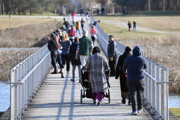 News Bilder des Tages Oeffentliches Leben in Zeiten der Corona Pandemie am 04.04.2020 im Riemer Park in Muenchen. Familien,Menschen,Personen beim Spazieren gehen ueber eine Bruecke am Riemer See. Spaziergang,Spaziergaenger. Das fruehlingshafte Wetter treibt die Bevoelkerung an die frische Luft,immer mit dem noetigen Abstand wegen einer Ansteckung mit dem Coronavirus. Ausgangsbeschraenkungen,Kontaktsperre.