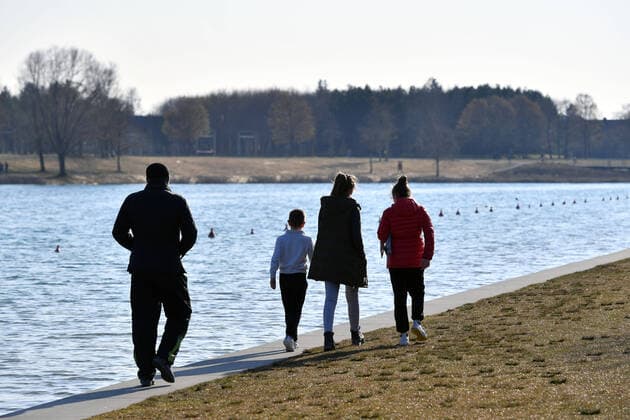 Oeffentliches Leben in Zeiten der Corona Pandemie am 04.04.2020 im Riemer Park in Muenchen. Familien,Menschen bei koerperlicher Betaetigung.Spazieren gehen. Spaziergang am Riemer See. Das fruehlingshafte Wetter treibt die Bevoelkerung an die frische Luft,immer mit dem noetigen Abstand wegen einer Ansteckung mit dem Coronavirus. Ausgangsbeschraenkungen,Kontaktsperre.