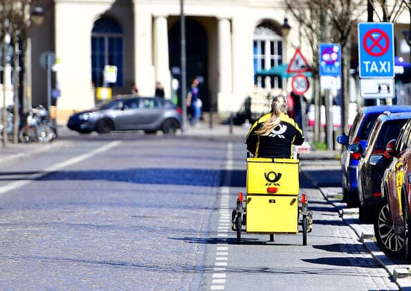 Oranienburg Covid-19,Corona,Virus,Coronavirus,Coronakrise,Krise, shut down,Coronakrise,Zustellbasis,Auto,Postauto,Scooter,Briefe ,Zusteller ,Wagen ,Anbieter,unternehmen,Postler,gelber,Postwagen ,Zustellung,Zustellwagen ,Brieftraegerwagen,Postbote, Konzern,DHL,Deutsche Post,Firmenlogo,Symbol ,Schriftzug,Aussenaufnahmen,draussen,Logo,Logos,Tag, Brandenburg,bei,Tage,Business,Aussenaufnahme, Zeichen ,Wirtschaft ,Deutschland ,auï¬‚en,Tageslicht 04.04.2020, Zustellerin mit dem Fahhrad der Deutschen Post beim ausliefern von Briefen Copyright: xEibnerxPressefotox xDanielxLakomskix EP_dli