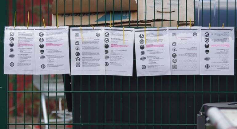Coronavirus-Pandemie: Am Eingang einer Wohnunterkunft für Flüchtlinge und Asylanten in Hamburg sind in mehreren Sprachen Hinweise zum Verhalten und zu Maßnahmen angebracht.