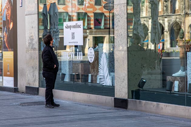 Mann mit Mundschutz spaziert in Fußgängerzone vorbei an geschlossenem Geschäft mit Schild Onlineshopping in Zeit der Ausgangsbeschränkung zur Eindämmung des Corona Virus Impressionen Draußen in der Ausgangsbeschränkung Corona Virus in München