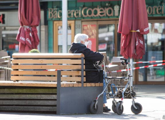 04.04.2020, xtgx, Auswirkungen des Corona Virus in Wolfsburg, eine Seniorin mit Mundschutz sitzt neben ihrem Rollator auf einer Bank, Symbolfoto, Symbolbild, Renter, alte Menschen, Risikogruppe, Risikopatienten Wolfsburg