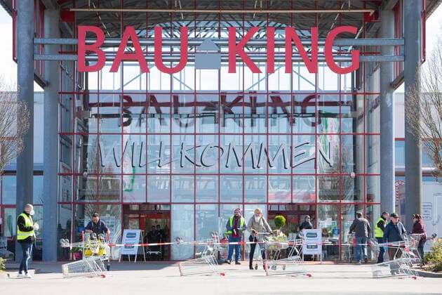 04.04.2020, xtgx, Auswirkungen des Corona Virus in Wolfsburg, Mitarbeiter des Sicherheitsdienstes kontrollieren den Eingang des Bau King (Hagebaumarkt, Hagebau, Baumarkt) in Vorsfelde (Wolfsburg). In Niedersachsen duerfen seit diesem Samstag die Baumaerkte wieder fuer Privatpersonen oeffnen, allerdings darf nur eine bestimmte Zahl von Kunden mit Einkaufswagen in den Markt. Wolfsburg