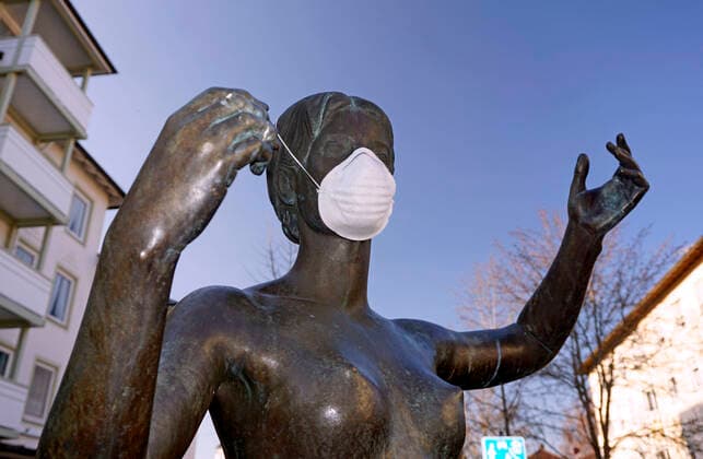 05.04.2020, Ladengeschäfte und Restaurants schliessen wegen Corona-Virus-Pandemie in Bad Wörishofen, Einer Skulptur am Kurhaus hat jemand eine Atemmaske verpasst. 05.04.2020, Symbolbild Corona-Virus 05.04.2020, Symbolbild Corona-Virus
