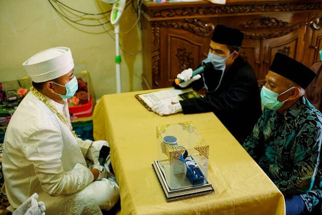 Wedding ceremony, during the COVID-19 coronavirus outbreak in Jakarta - April 5, 2020. A groom and a bride wearing a face mask during wedding ceremony while amid the COVID-19 coronavirus outbreak in Jakarta, Indonesia, on April 5, 2020. (Photo by Ahmad Soleh INA Photo Agency imago images) 