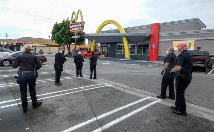 April 5, 2020, Los Angeles, California, U.S: Police officers wearing face masks as workers take part in a drive-thru strike at a McDonald s restaurant on Sunday, April 5, 2020 in Los Angeles. The workers are demanding a two-week quarantine period, with full pay for a co-worker who tested positive for COVID-19. Los Angeles U.S. - ZUMAc68_ 20200405_zaf_c68_006 Copyright: xRingoxChiux