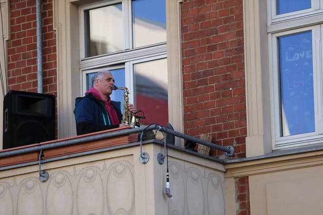Die Musiker Kai Mader (Saxophon), Nicolas Schulze (Klavier), Philip Meister (Gitarre) und Buchan Heiß (Bass) geben ein Jazzkonzert von ihren Balkonen in der Schlaatzstraße in Potsdam, 5. April 2020. Um die Ausbreitung des Coronavirus Sars-CoV-2 zu verlangsamen gelten z.Zt. u.a. Ausgangs- und Kontaktbeschränkungen. Jazz gegen Social Distancing in Potsdam