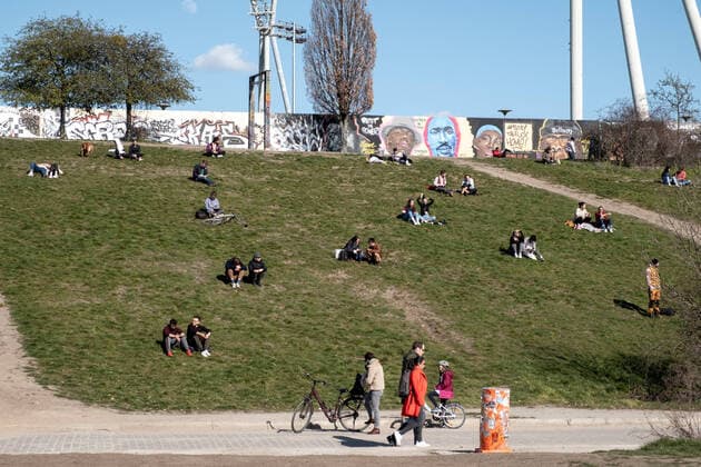 Zuweit oder alleine und mit genügend Abstand geniessen die Berliner das Frühlingswetter im Berliner Mauerpark. Coronakrise - Alltag mit dem Virus