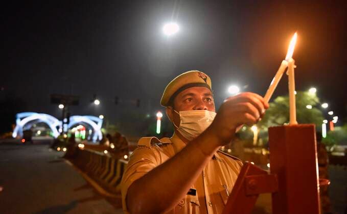 NEW DELHI, INDIA APRIL 5: A Police personnel light candles in a show of solidarity and support for frontline workers, on day twelve of the nationwide lockdown to combat coronavirus, at Delhi-Noida border, near Mayur Kunj, on April 5, 2020 in New Delhi, India. Millions of Indians across the country switched off lights at their homes and lit candles and diyas or turned on mobile phone torches on Sunday night, responding to Prime Minister Narendra Modi s appeal to show the nation s collective resolve and solidarity in its fight against coronavirus with this symbolic gesture. (Photo by Mohd Zakir Hindustan Times ) Millions Of Indians Light Candles, Diyas, Turn On Mobile Phone Torches After Prime Minister Modi?s Appeal