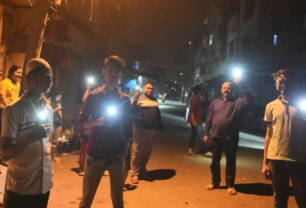 NEW DELHI, INDIA APRIL 5: People with mobile flashlights in a show of solidarity and support for frontline workers, on day twelve of the nationwide lockdown to combat coronavirus, at Seelampur, on April 5, 2020 in New Delhi, India. Millions of Indians across the country switched off lights at their homes and lit candles and diyas or turned on mobile phone torches on Sunday night, responding to Prime Minister Narendra Modi s appeal to show the nation s collective resolve and solidarity in its fight against coronavirus with this symbolic gesture. (Photo by Sonu Mehta Hindustan Times ) Millions Of Indians Light Candles, Diyas, Turn On Mobile Phone Torches After Prime Minister Modi?s Appeal