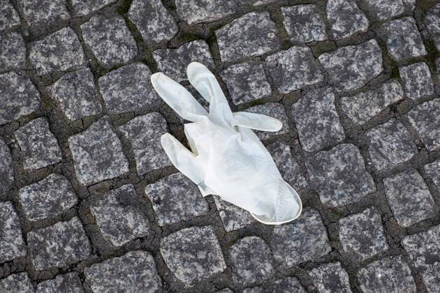 Ausgedienter OP-Handschuh liegt auf der Strasse. Coronakrise - Müll