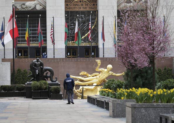 A security guard worker walks in Rockefeller Center which is empty of pedestrian traffic on Palm Sunday In New York City on Sunday, April 5, 2020. Cardinal Timothy Dolan today held a virtual Palm Sunday mass from St. Patrick s Cathedral. Coronavirus cases in the U.S. rose to over 300,000 and the number of deaths rose to more than 8,000 Globally the death toll has been reported at more than 65,000.  NYP20200405117 JOHNxANGELILLO