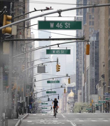 A cyclist rides on an almost empty of pedestrian and automobile traffic 5th Avenue on Palm Sunday In New York City on Sunday, April 5, 2020. Cardinal Timothy Dolan today held a virtual Palm Sunday mass from St. Patrick s Cathedral. Coronavirus cases in the U.S. rose to over 300,000 and the number of deaths rose to more than 8,000 Globally the death toll has been reported at more than 65,000.  NYP20200405121 JOHNxANGELILLO