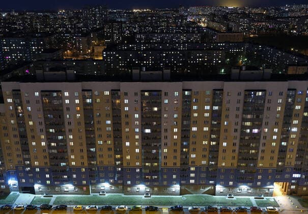 ST PETERSBURG, RUSSIA - APRIL 5, 2020: Lit windows in apartment blocks in Nevsky District. A home isolation order was declared for St Petersburg residents of all ages to restrict movement within the city and reduce the risk of coronavirus contagion, effective since March 30, 2020; a period off work with full pay was extended until April 30 nationwide as part of preventive measures to contain the spread of the COVID-19 infection. Peter Kovalev TASS  TS0D4802