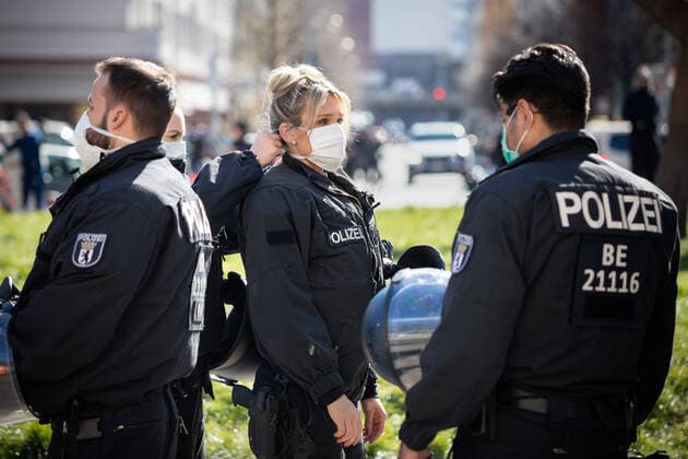 Verschwörungstheoretiker protestieren gg Corona-Einschränkungen Eine Polizistin hilft ihre Kollegin am Rande einer Demonstration von Verschwörungstheoretikern während der Eindeämmungsverordnung mit Ausgansbeschränkung, Demonstrationsverbot und Kontaktverbot zur Eindämmung der COVID-19 - Pandemie (Coronavirus SARS-CoV-2) in Berlin eine Atemschutzmaske anzulegen. Â Berlin Berlin Deutschland