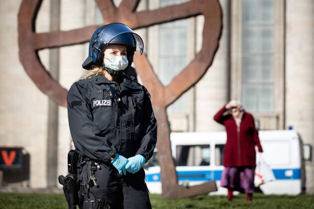 Verschwörungstheoretiker protestieren gg Corona-Einschränkungen Eine Polizistin mit Atemschutzmaske vor der Volksbühne am Rande einer Demonstration von Verschwörungstheoretikern während der Eindeämmungsverordnung mit Ausgansbeschränkung, Demonstrationsverbot und Kontaktverbot zur Eindämmung der COVID-19 - Pandemie (Coronavirus SARS-CoV-2) in Berlin. Â Berlin Berlin Deutschland