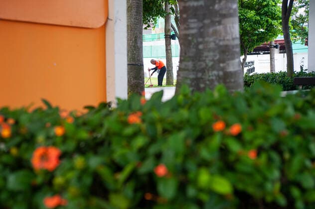 02.04.2020, Singapur, Republik Singapur, Asien - Ein Strassenkehrer reinigt einen Fussweg am Ufer in Marina Bay. Seit dem Ausbruch der Corona-Pandemie ist die Zahl auslaendischer Besucher komplett zurueck gegangen. Fuer gewoehnlich wimmelt die Gegend um Marina Bay von Touristen, ist jetzt aber bis auf wenige Personen total verwaist.