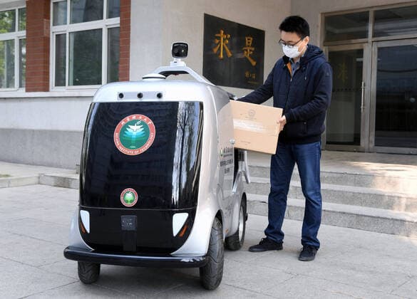 (200406) -- BEIJING, April 6, 2020 -- A member of staff puts goods into the 5G unmanned delivery car at the Beijing Institute of Technology in Beijing, capital of China, April 6, 2020. A 5G unmanned delivery car was put into use at the Beijing Institute of Technology, which can measure the temperature of people entering the campus, recognise facial information, and also can conduct no-touch delivery. ) CHINA-BEIJING-CAMPUS-UNMANNED DELIVERY CAR (CN) RenxChao 