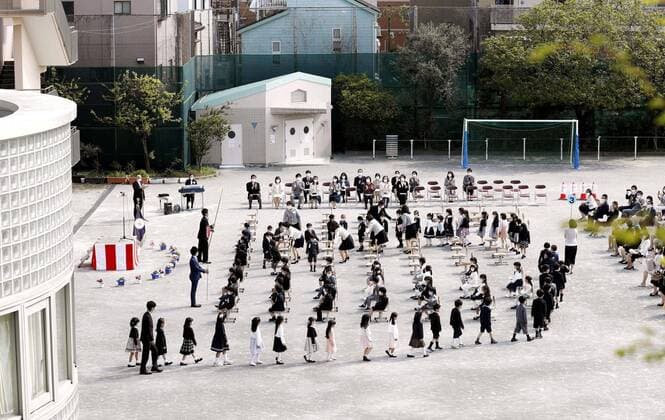 School enrollment ceremony outdoors An enrollment ceremony for new students is held at the playground of Senju Sakura elementary school in Tokyo on April 6, 2020, amid concerns over the new coronavirus. Such a ceremony is usually held indoors in Japan. 